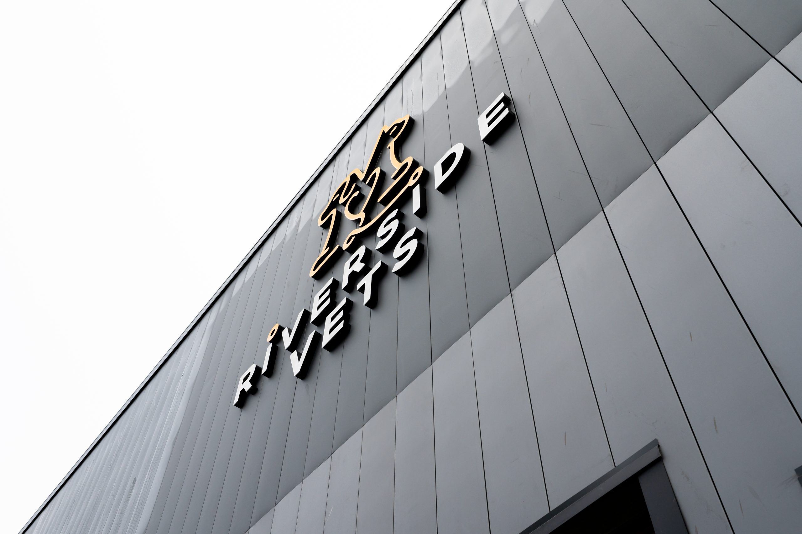 Exterior of Riverside Vets building with modern cladding and a prominent 3D logo featuring a stylized animal figure.