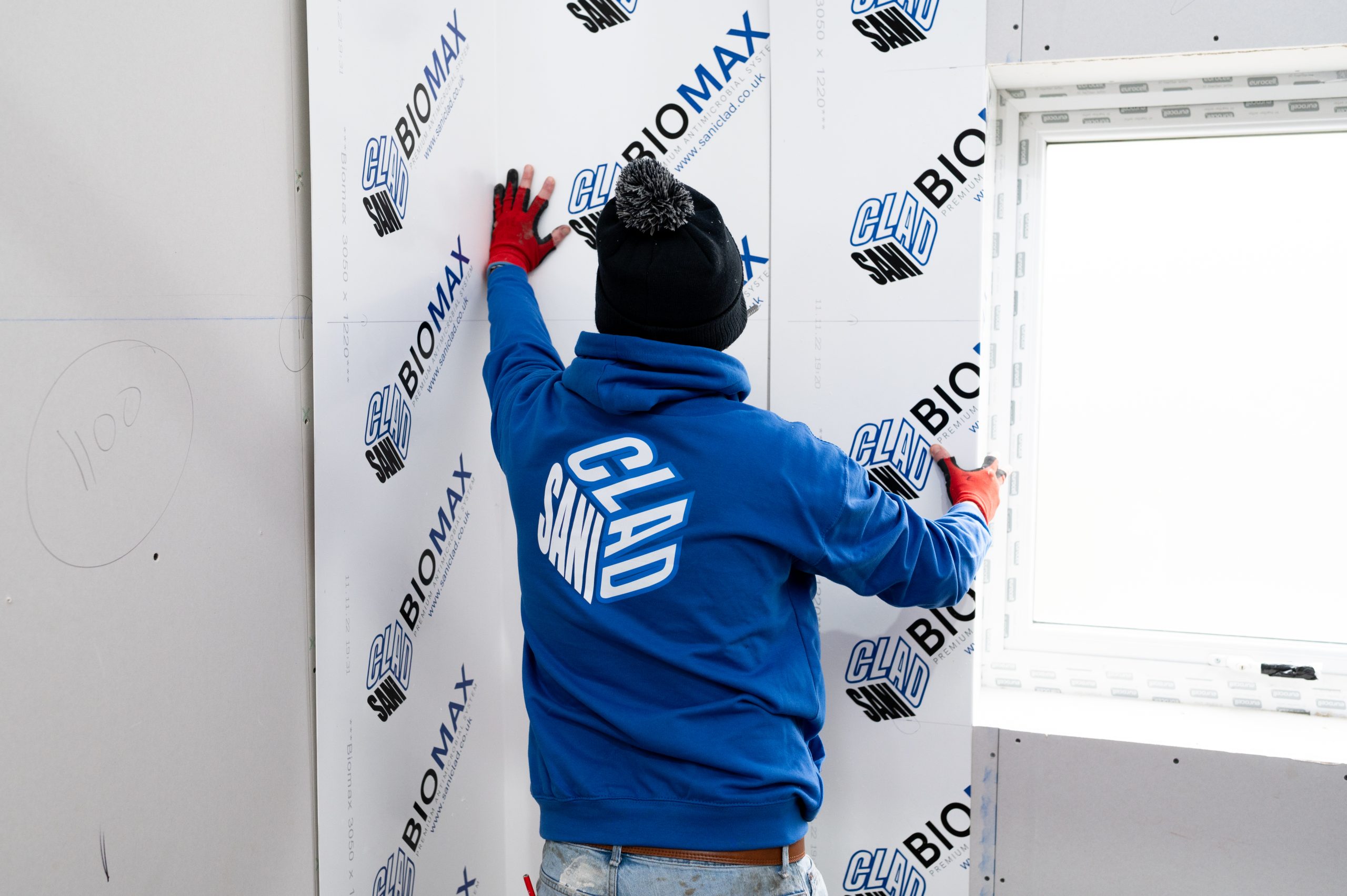 DSC_9130 Worker applying BIOMAX™ Hygienic Wall Cladding, showcasing durable and hygienic wall cladding technology.
