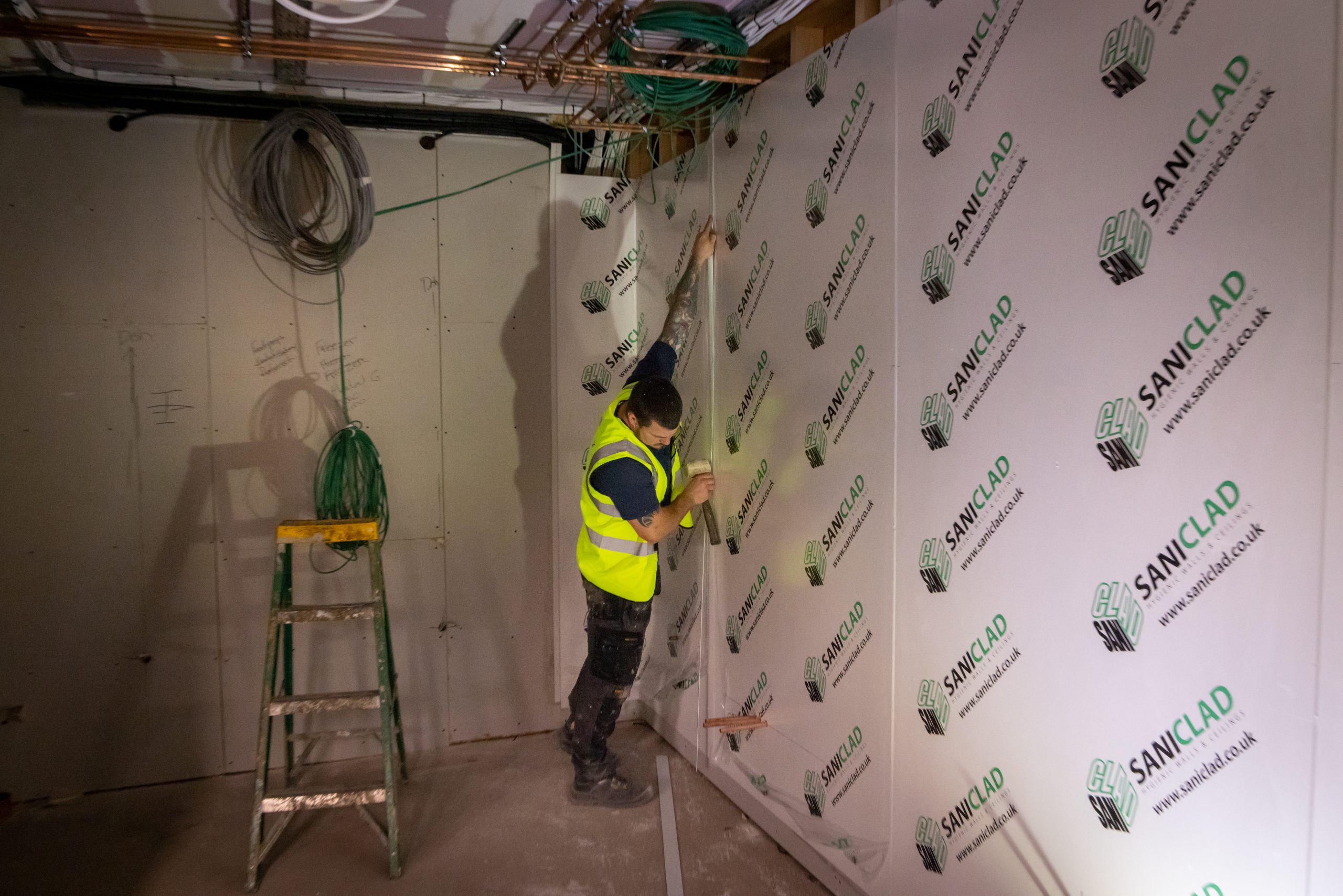 Worker putting hygienic cladding on the wall